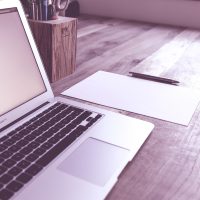 虎扑 nba 主编在深色书房里对着笔记本整理当日赛程要点，屏幕橙光映在脸上的夜班工作状态